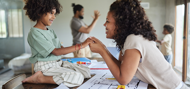 Mother and daughter holding hands over home renovation plans